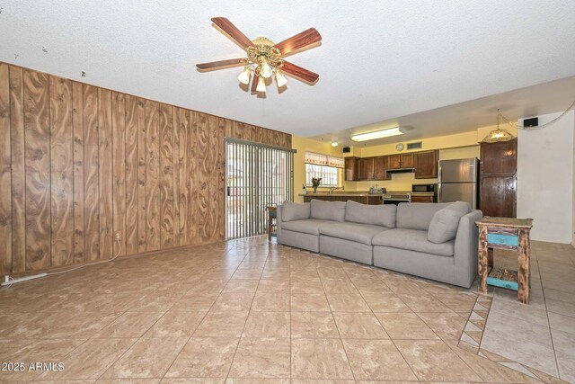 18012 N 37th Dr, Glendale, AZ 85308 - living room with wood walls, a textured ceiling, a ceiling fan, and light tile patterned flooring