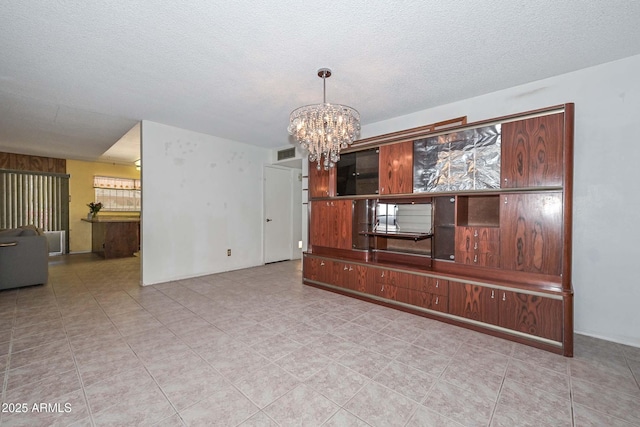 18012 N 37th Dr, Glendale, AZ 85308 - unfurnished living room with a chandelier, a textured ceiling, tile patterned flooring, and visible vents