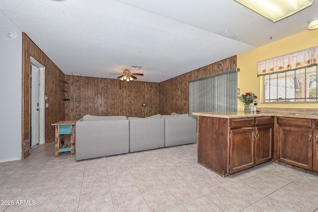 18012 N 37th Dr, Glendale, AZ 85308 - kitchen with wooden walls, light countertops, a ceiling fan, a textured ceiling, and light tile patterned flooring