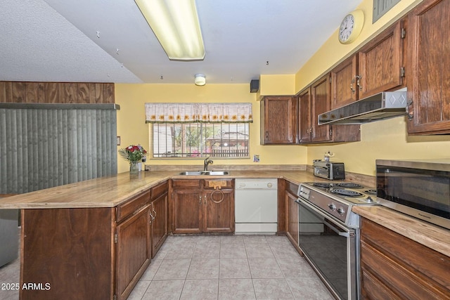 18012 N 37th Dr, Glendale, AZ 85308 - kitchen featuring light tile patterned floors, a peninsula, under cabinet range hood, appliances with stainless steel finishes, and a sink