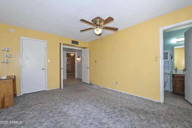 18012 N 37th Dr, Glendale, AZ 85308 - unfurnished bedroom with visible vents, a ceiling fan, a textured ceiling, carpet floors, and ensuite bath