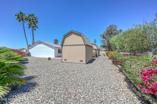 18012 N 37th Dr, Glendale, AZ 85308 - view of side of property with crawl space, a gambrel roof, fence, and an outdoor structure