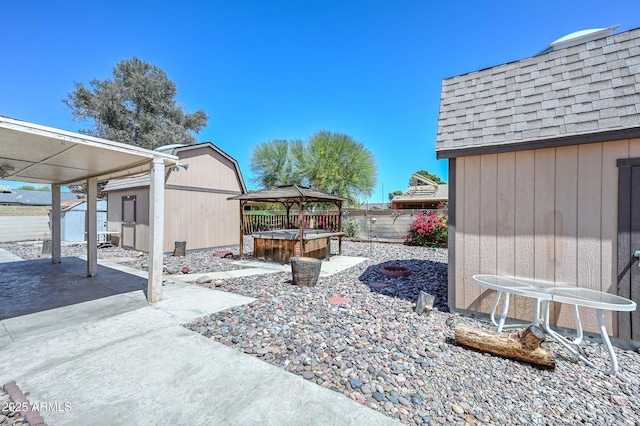 18012 N 37th Dr, Glendale, AZ 85308 - view of patio with a shed, a hot tub, a gazebo, a fenced backyard, and an outdoor structure
