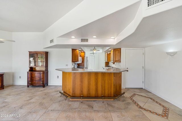 kitchen featuring stainless steel fridge, kitchen peninsula, and ceiling fan