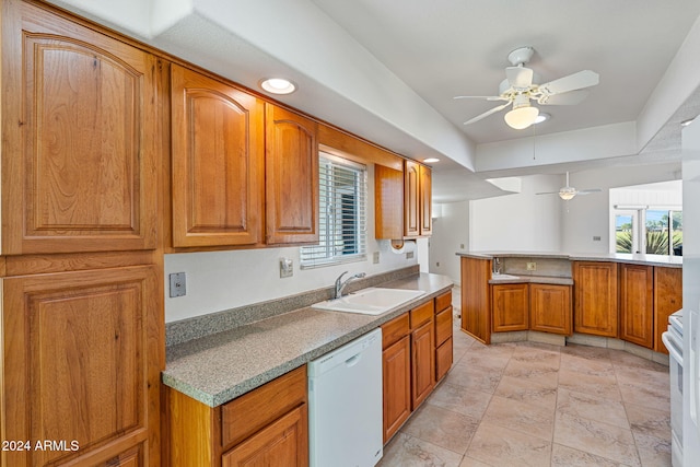 kitchen with white appliances, ceiling fan, sink, and kitchen peninsula