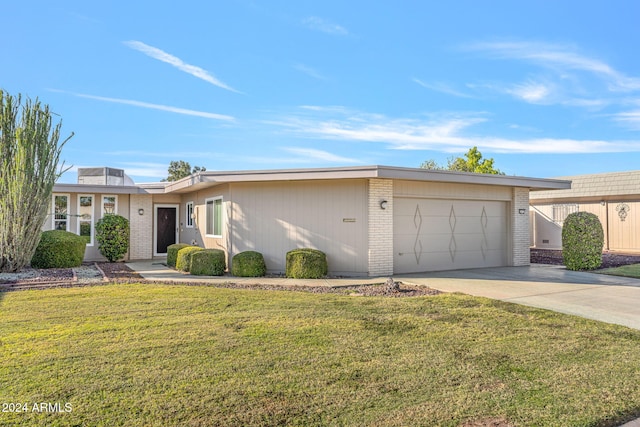 ranch-style house with a front yard and a garage