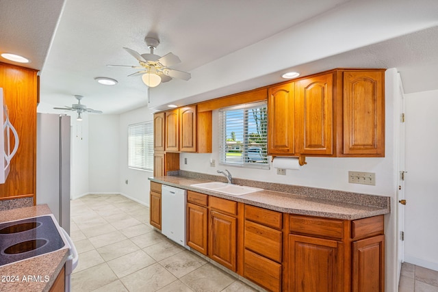 kitchen with sink, dishwasher, stainless steel range oven, ceiling fan, and light tile patterned floors