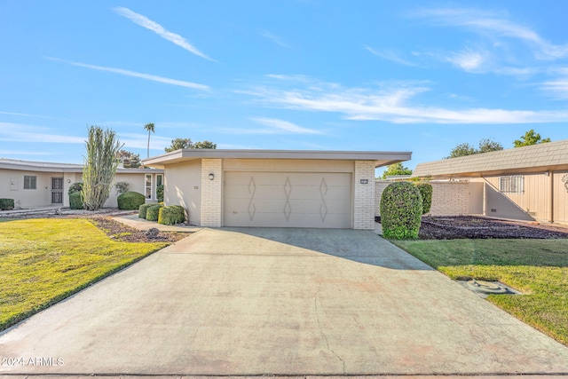 single story home featuring a front yard and a garage