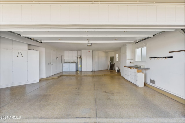 garage featuring water heater and separate washer and dryer