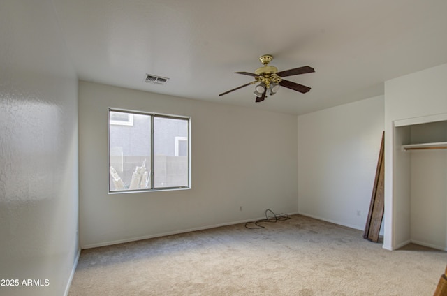 unfurnished bedroom with a closet, visible vents, light carpet, ceiling fan, and baseboards