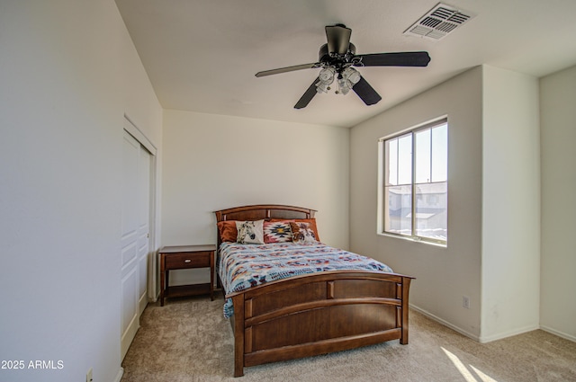 bedroom featuring ceiling fan, visible vents, and light colored carpet