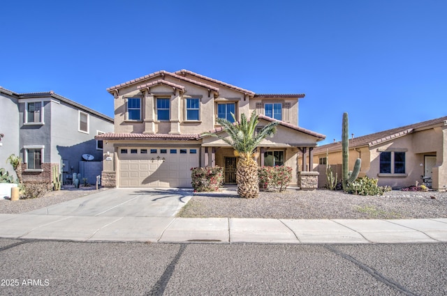 mediterranean / spanish-style house featuring driveway, a tiled roof, an attached garage, and stucco siding