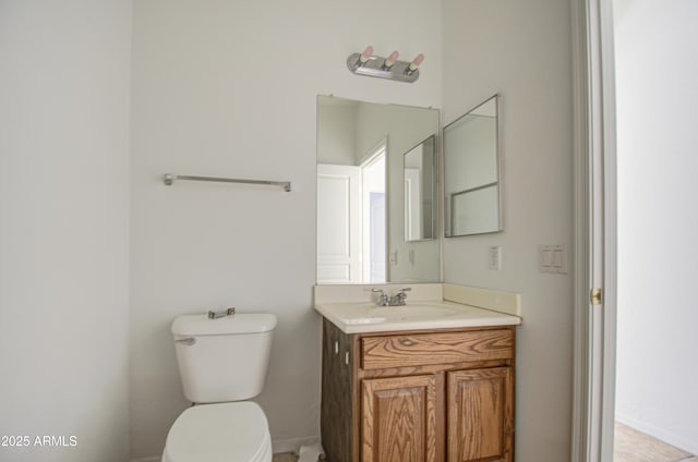 half bath featuring vanity and toilet