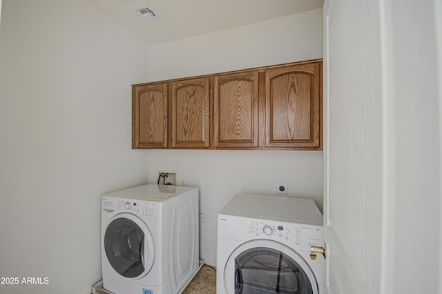 clothes washing area featuring cabinet space, visible vents, and washer and clothes dryer