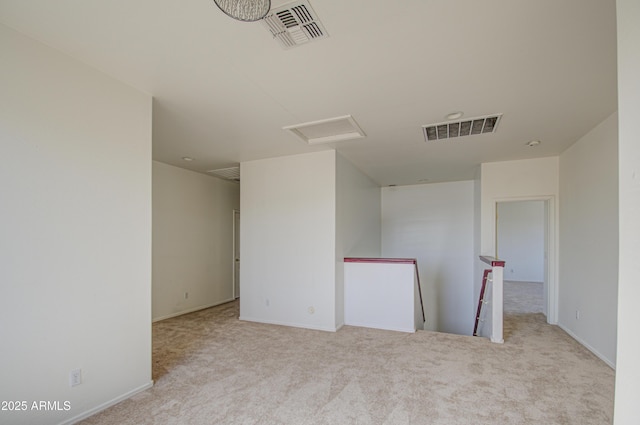 empty room with light carpet, attic access, and visible vents