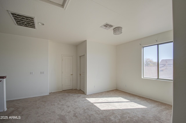 unfurnished room featuring light colored carpet, visible vents, and baseboards