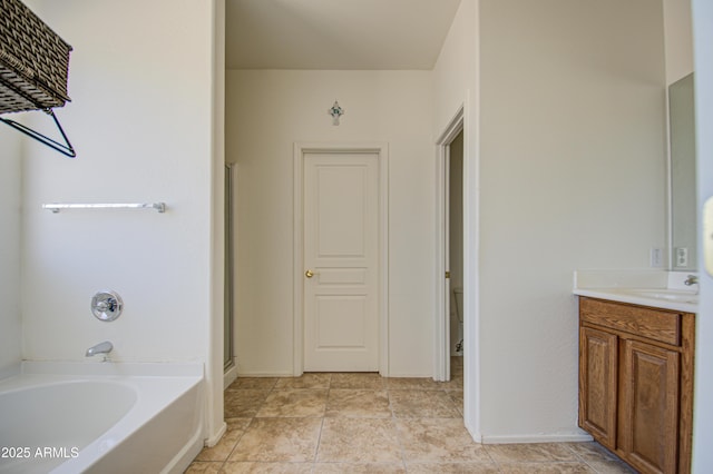 bathroom featuring a washtub, a shower with door, vanity, and baseboards