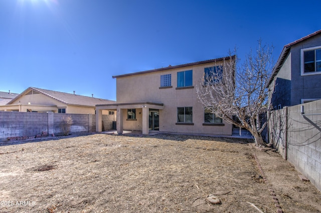 rear view of property with a fenced backyard and stucco siding