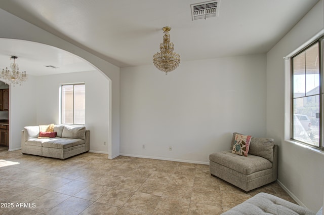 sitting room with arched walkways, baseboards, visible vents, and an inviting chandelier