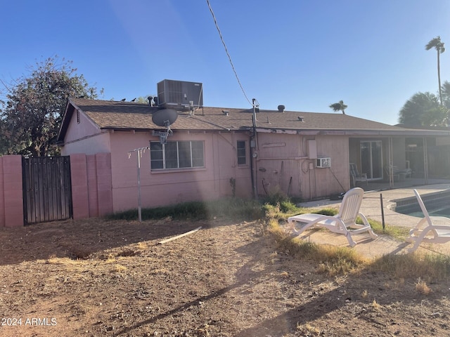 rear view of house with central air condition unit and a patio area