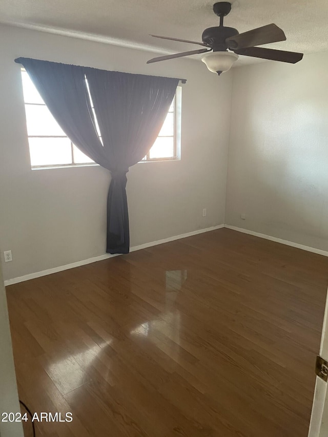 spare room featuring ceiling fan and dark hardwood / wood-style flooring