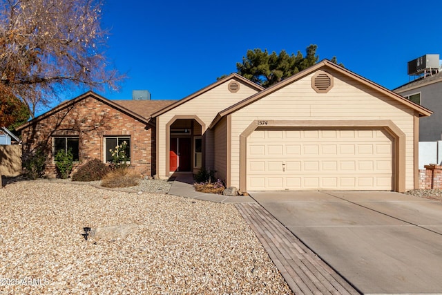 single story home featuring central AC unit and a garage