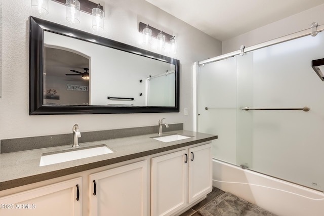 bathroom with ceiling fan, vanity, and bath / shower combo with glass door