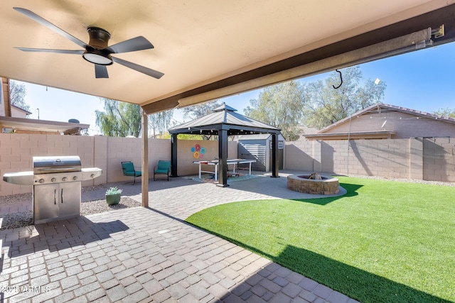 view of patio featuring a gazebo, ceiling fan, an outdoor fire pit, and a grill