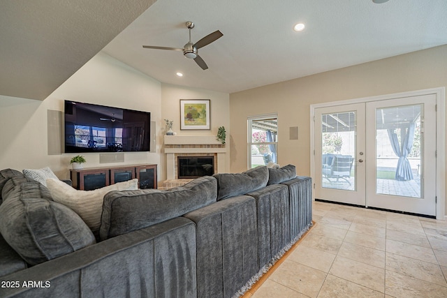 living area with light tile patterned flooring, vaulted ceiling, french doors, a brick fireplace, and recessed lighting