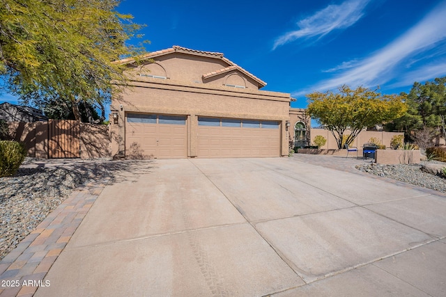 view of front of house featuring concrete driveway, fence, a tiled roof, and stucco siding