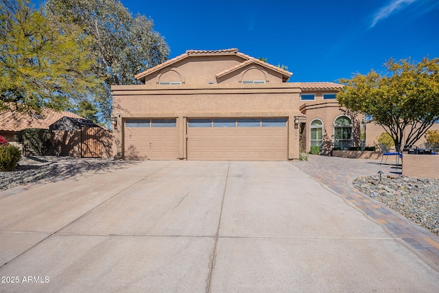 view of front of home with an attached garage, a tile roof, concrete driveway, and stucco siding