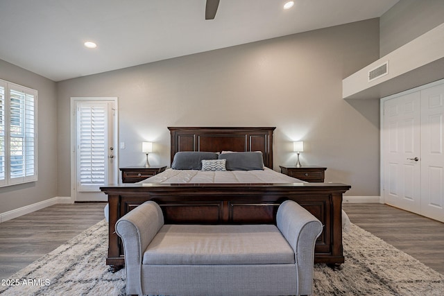 bedroom featuring recessed lighting, visible vents, vaulted ceiling, wood finished floors, and baseboards