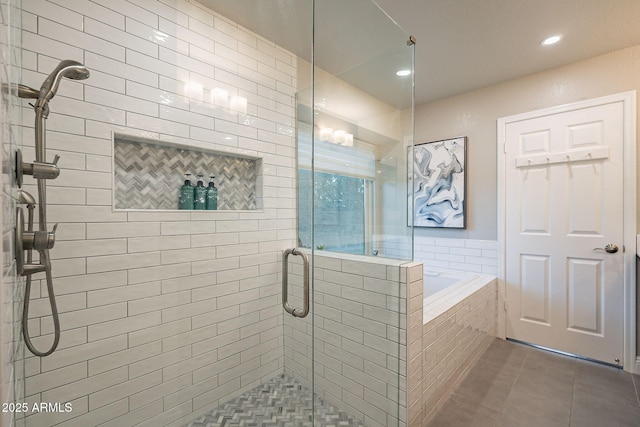 bathroom with a stall shower, tile patterned flooring, and a garden tub