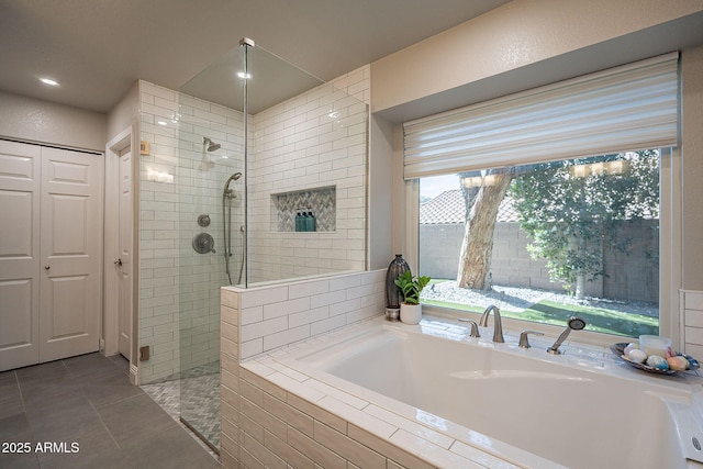 full bathroom with a closet, tile patterned flooring, walk in shower, and a bath