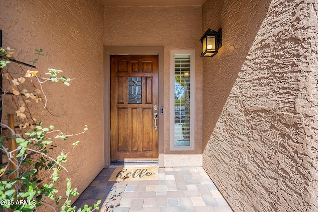 view of exterior entry with stucco siding