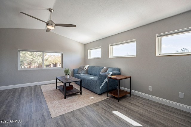 living room with dark wood-style floors, a wealth of natural light, and baseboards