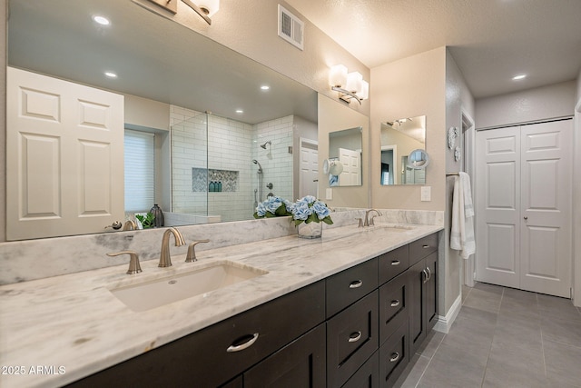 full bath featuring a closet, visible vents, a sink, and tile patterned floors