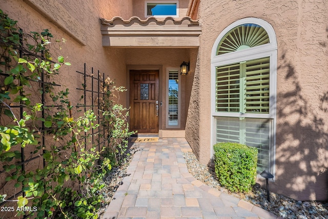 doorway to property with a tiled roof and stucco siding