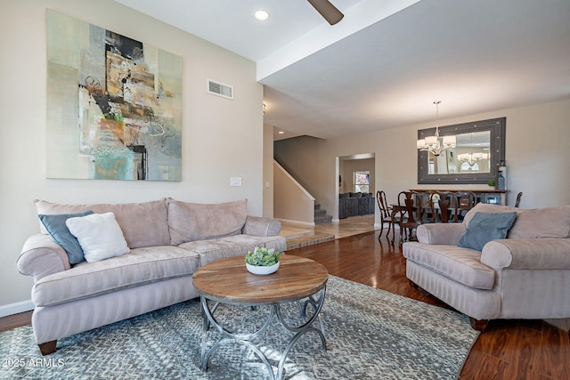 living area with visible vents, dark wood finished floors, baseboards, and stairs