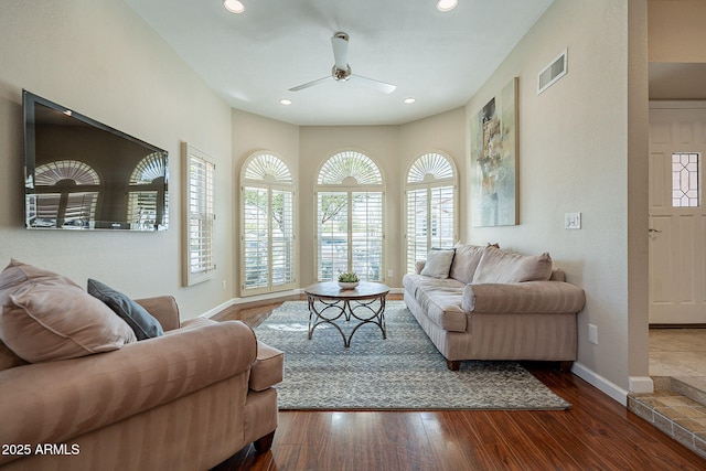 living area featuring recessed lighting, dark wood-style flooring, visible vents, and baseboards