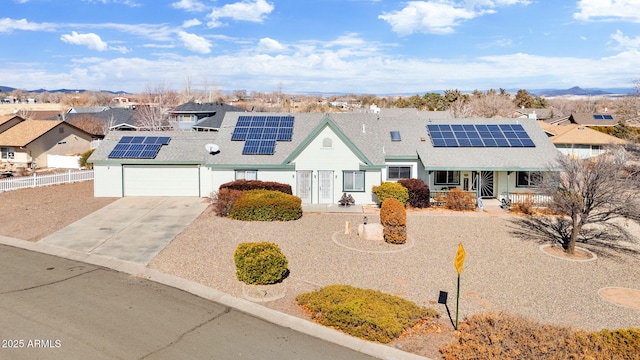 view of front facade featuring solar panels and a garage