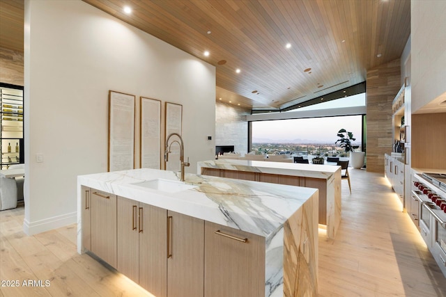 kitchen featuring sink, wood ceiling, a spacious island, and light wood-type flooring