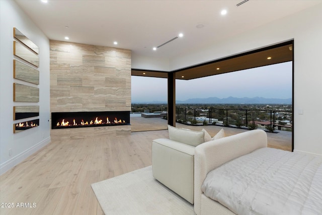 living room with a mountain view, a tile fireplace, and light hardwood / wood-style floors