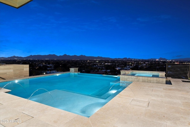 view of swimming pool featuring pool water feature, an in ground hot tub, a mountain view, and a patio area