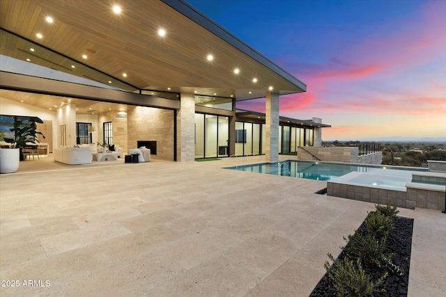 pool at dusk featuring a patio