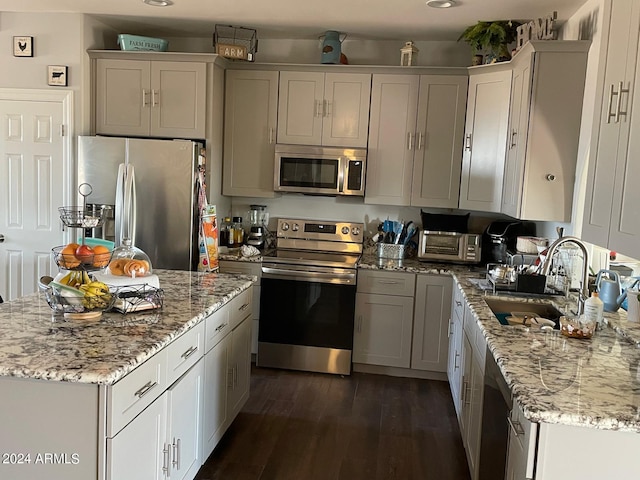 kitchen with a center island, stainless steel appliances, sink, and dark wood-type flooring