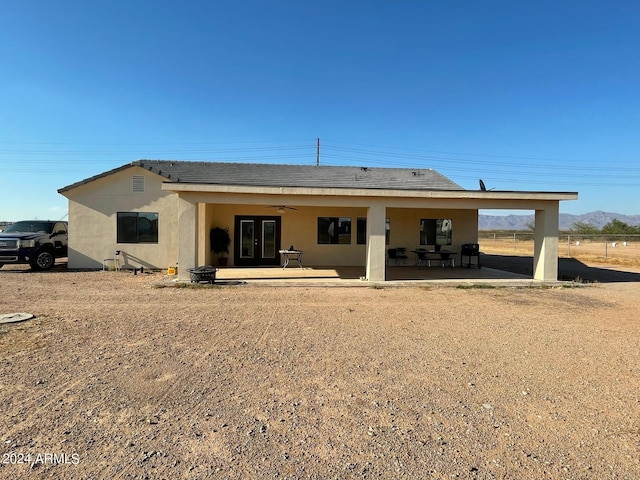 rear view of house featuring ceiling fan and a patio area