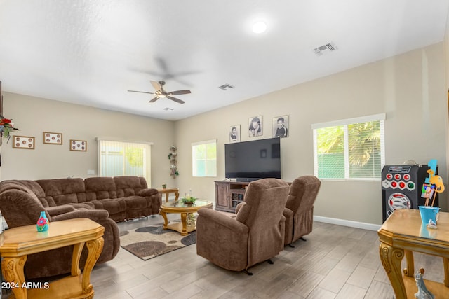 living room with light wood-type flooring, a wealth of natural light, and ceiling fan