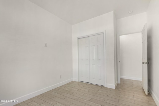 unfurnished bedroom featuring a closet and light hardwood / wood-style floors