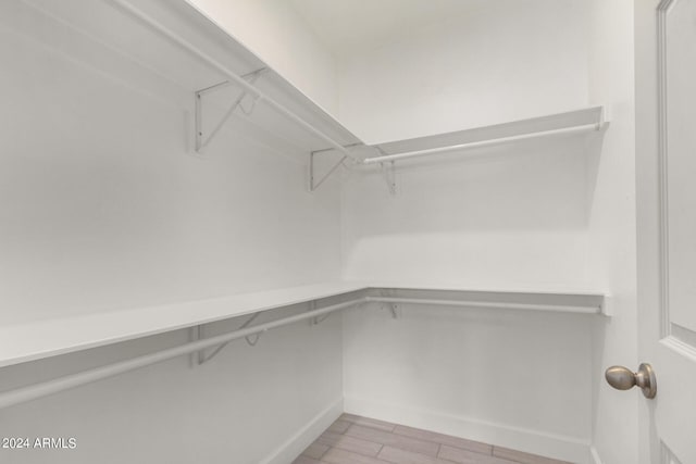 spacious closet with light hardwood / wood-style flooring